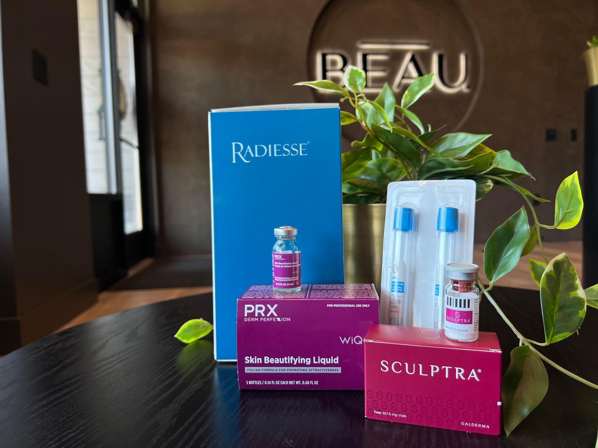 Luxury skincare products displayed on a table with green leaves and a branded store background